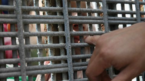La verja que separa México de Estados Unidos apenas permite introducir el dedo pequeño en busca de un contacto.