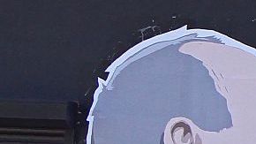 Una mujer pasa junto a un mural en un restaurante que representa al candidato presidencial Donald Trump y el presidente ruso, Vladimir Putin, que se saludan con un beso en Vilnius, Lituania.