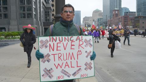 Un manifestante con cartel en mano que reza: “Never Trump Wall en el centro de Chicago”.