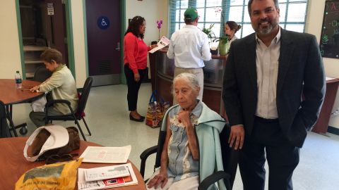 Rigo Saborio, director de St.Barnabas Senior Center, junto a una señora que recibe ayuda del lugar.