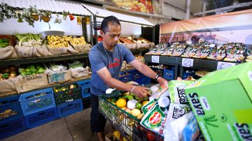 Jaime Delgado llena un carro de mercado de alimentos para su familia, por $30 solamente.