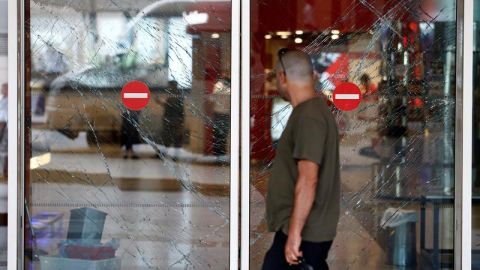 Un hombre observa los cristales rotos de una puerta tras el atentado en el aeropuerto internacional de Atatürk en Estambul.