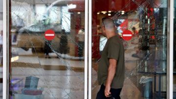 Un hombre observa los cristales rotos de una puerta tras el atentado en el aeropuerto internacional de Atatürk en Estambul.