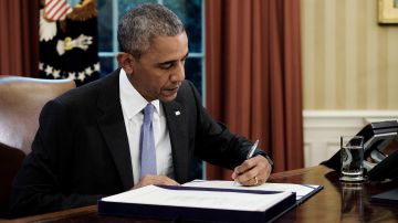 Obama firma la ley de refinanciación de Puerto Rico en la Oficina Oval de la Casa Blanca.