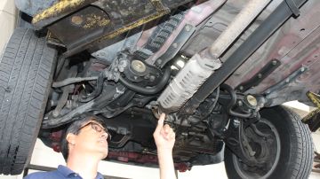 Miguel Batanero, propietario de Technology Automotive en Montebello inspecciona el catalizador de una camioneta Honda CRV.