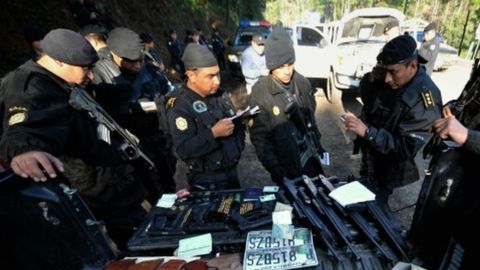 Policías en Guatemala observan un arsenal decomisado al cartel de Los Zetas.