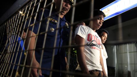 En la imagen, un policía vigila a delincuentes detenidos en Manila en operaciones antidrogas.