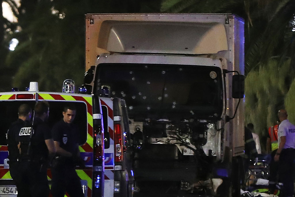 Policías cerca de una furgoneta, con su parabrisas acribillado, que chocó contra una multitud durante un espectáculo de fuegos artificiales en la ciudad de Niza, en Francia.