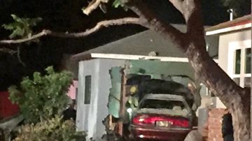 Imágenes en la televisión mostraba que casi todo el auto se incrustó dentro de la casa. Apenas la parte trasera del auto salía del boquete en la pared del hogar. /NBC4 LA
