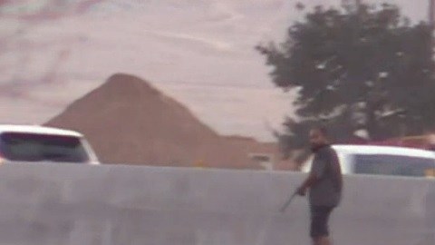 El hombre, no identificado, fue captado con rifle en mano sobre la autopista 215.