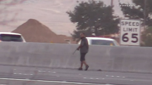 El hombre, no identificado, fue captado con rifle en mano sobre la autopista 215.