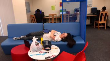 Una mujer duerme en una biblioteca de Los Ángeles, resguardándose de las altas temperaturas.
