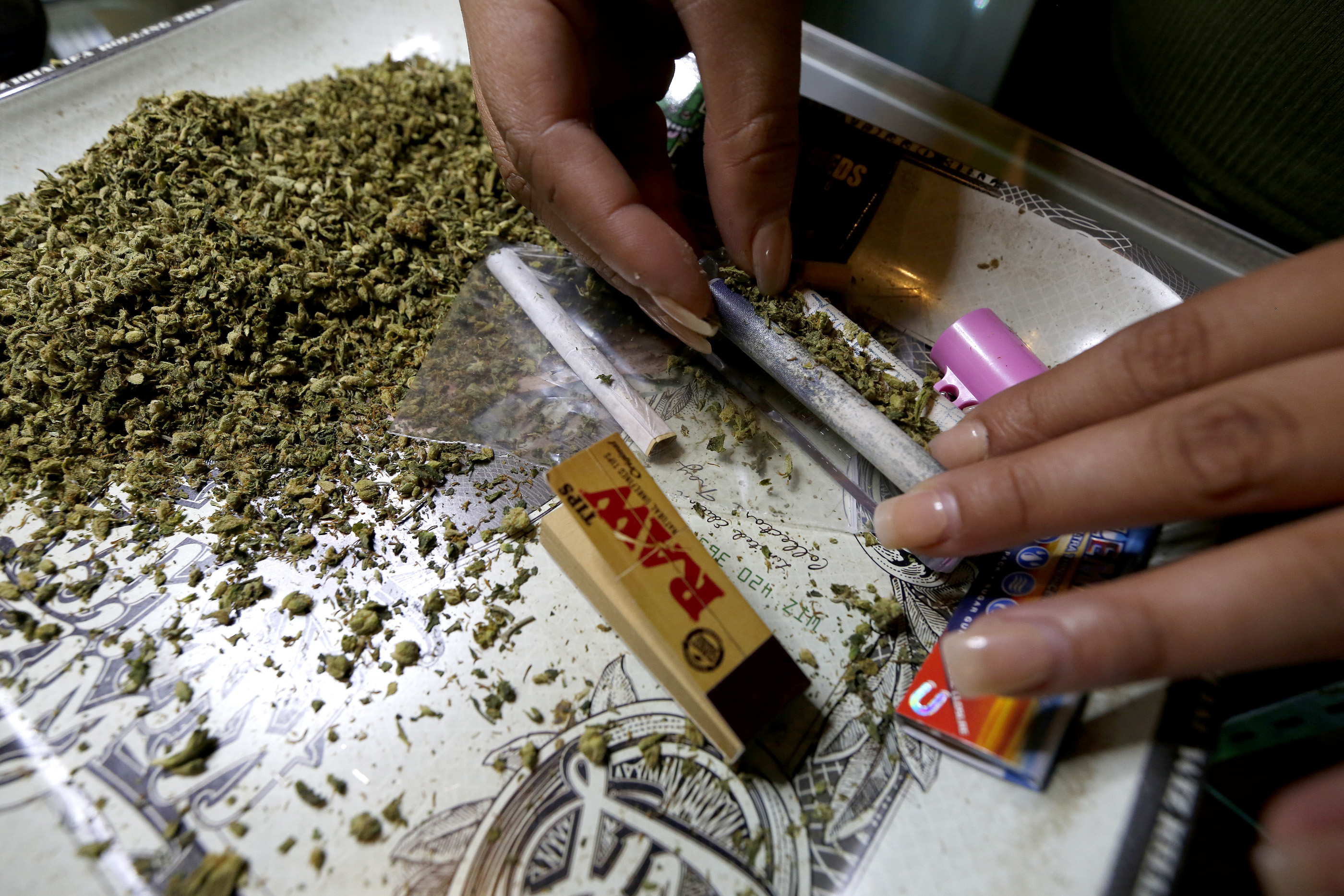 La empleada de un negocio de marihuana en Los Ángeles prepara cigarillos de la hierba para vender. (Aurelia Ventura/ La Opinion)