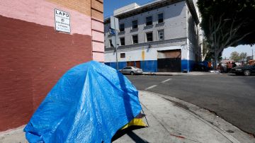 Personas sin hogar duermen frente al edificio de Salvation Army que sería convertido en pequeños apartamentos de lujo bajo un proyecto que está en planeación. (Aurelia Ventura/ La Opinion)