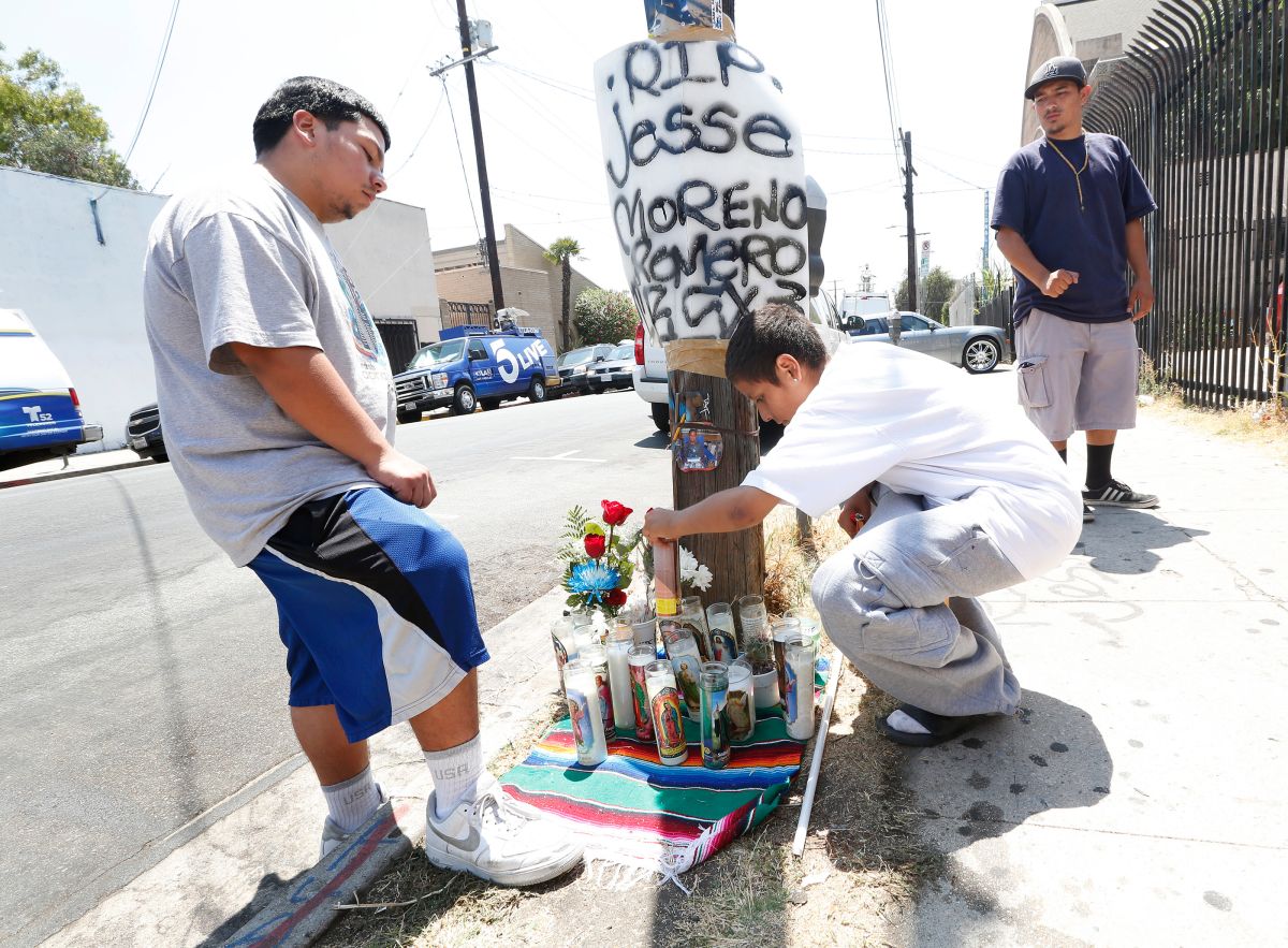 Richard Romero, hermano menor de Jesse Romero, coloca velas en el altar erguido en honor a su hermano mayor. (Aurelia Ventura/ La Opinion)