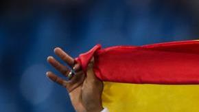 Ortega festeja la medalla de plata envuelto en la bandera española.