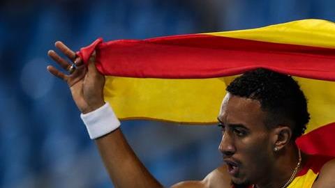 Ortega festeja la medalla de plata envuelto en la bandera española.