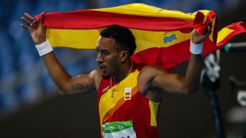 Ortega festeja la medalla de plata envuelto en la bandera española.