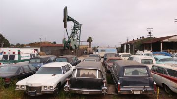 Un pozo petrolero muy cerca a un patio de autos en Los Ángeles.