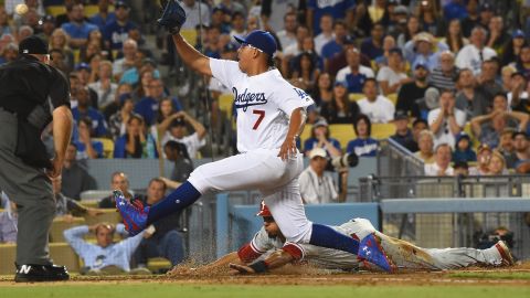 Julio Urías no puede impedir la carrera de Aaron Altherr, de los Filis, tras un error del pitcher de los Dodgers en la tercera entrada.