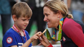 La ciclista Kristin Armstrong muestra la medalla de oro a su hijo.