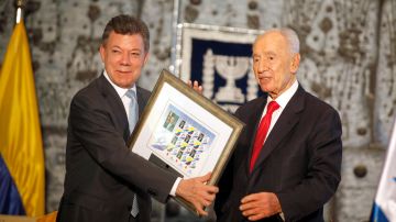 Shimon Peres (dcha) entrega un regalo al presidente de Colombia, Juan Manuel Santos, en 2013 en Jerusalén.