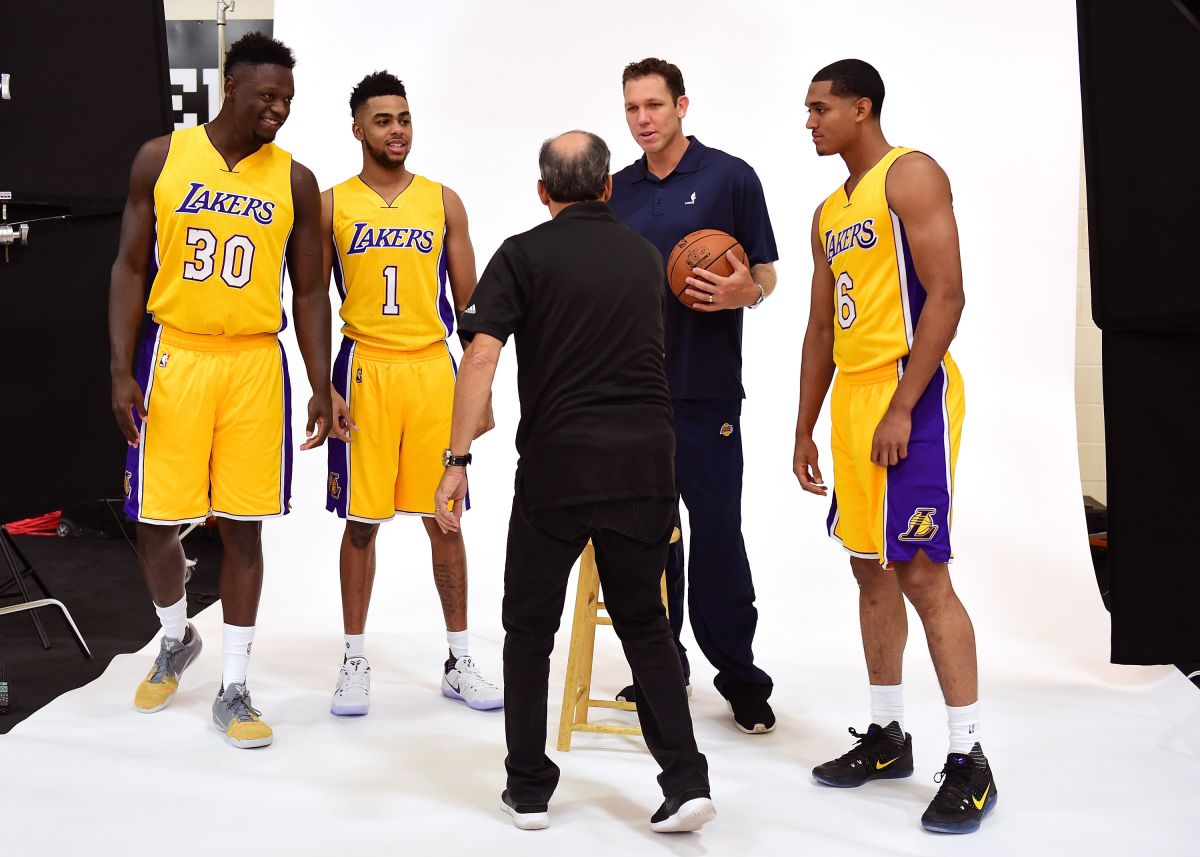 Los jugadores de los Lakers (de izq. a der.) Julius Randle, D'Angelo Russell y Jordan Clarkson se acomodan con su nuevo entrenador Luke Walton para una sesión de fotos en el día de medios del equipo.