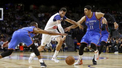 El alero del Real Madrid, Rudi Fernández  intenta superar la defensa de los jugadores del Oklahoma City Thunder, Russell Westbrook y el pivot turco Enes Gulen.