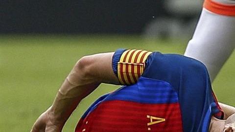 El centrocampista del FC Barcelona, Andrés Iniesta se duele de la entrada del jugador del Valencia Enzo Pérez.
