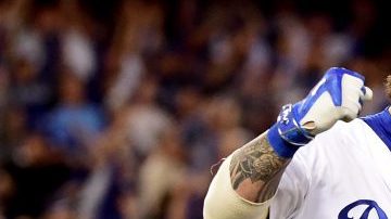 Yasmani Grandal reacciona al conectar un jonró de dos carreras en el cuarto inning. Los Dodgers ganaron 6-0 a los Cachorros y la Serie Mundial está a la vista.