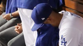 Julio Urías se lamenta en la caseta de los Dodgers tras haber sido sacado del juego en un cuarto inning en el que los Cachorros le anotaron cuatro carreras, en el juego 4 de la Serie de Campeonato.