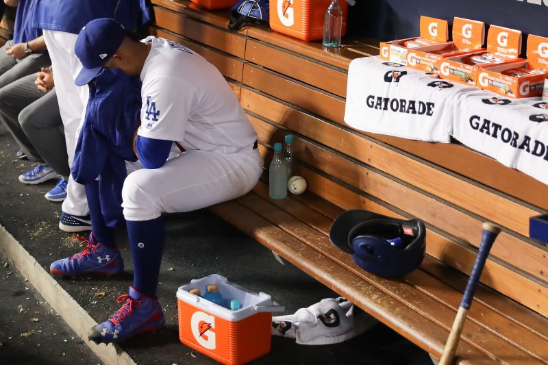 Julio Urías se lamenta en la caseta de los Dodgers tras haber sido sacado del juego en un cuarto inning en el que los Cachorros le anotaron cuatro carreras, en el juego 4 de la Serie de Campeonato.