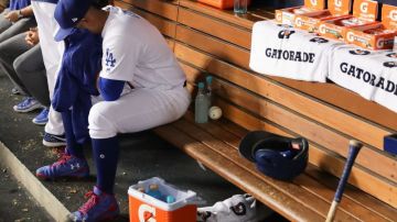 Julio Urías se lamenta en la caseta de los Dodgers tras haber sido sacado del juego en un cuarto inning en el que los Cachorros le anotaron cuatro carreras, en el juego 4 de la Serie de Campeonato.