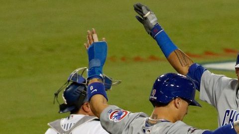 Javier Báez (9) y Addison Russell (27) celebran el jonrón de dos carreras de éste en la sexta entrada que dio lugar a otra paliza de Chicago en la Serie de Campeonato de la Liga Nacional.