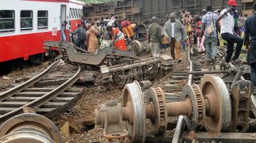 Pasajeros del tren salen del sitio del accidente en Eseka, Camerún.