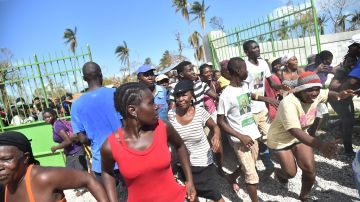 Vícttimas del huracán Matthew en la entrega de un paquete de ayuda de la ONU en Tobeck, Les Cayes, Haití
