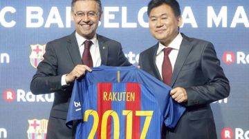 El presidente del FC Barcelona, Josep Maria Bartomeu (i), y el presidente de la empresa japonesa Rakuten, Hiroshi Mikitani, posan con la camiseta del nuevo patrocinador del club.