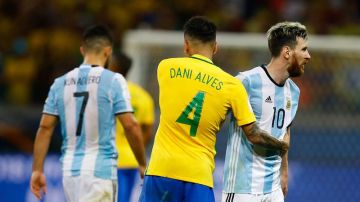 Daniel Alves de Brasil saluda a Lionel Messi de Argentina.