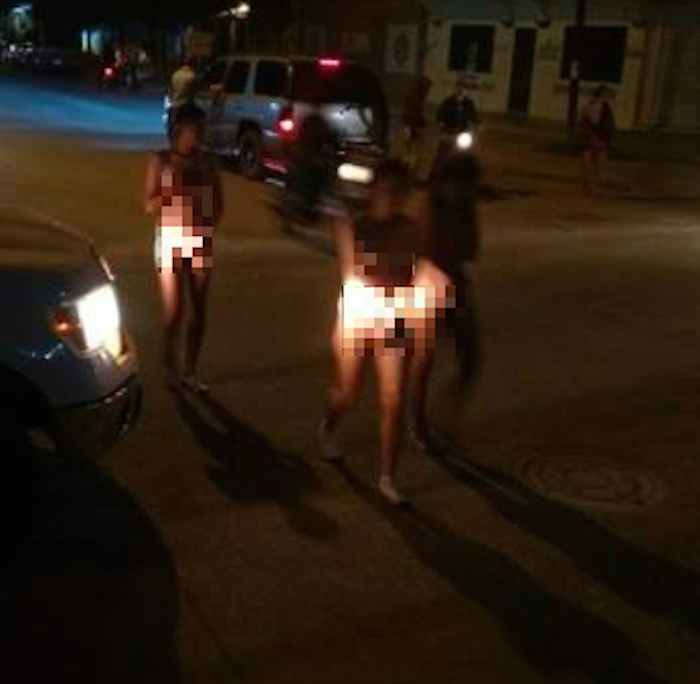 En la imagen, las tres mujeres obligadas a caminar desnudas son acompañadas por locatarios. 
