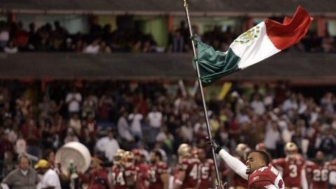 Robert Griffith, de los Cardinals de Arizona, salta al campo del Estadio Azteca con una bandera de México antes del juego del 2 de octubre de 2005 contra San Francisco, el primer juego oficial de la NFL fuera de los Estados Unidos.