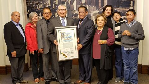 Fotografía cedida en donde aparece el fundador de la organización El Rescate, Salvador Sanabria (4 izq.) recibiendo el pergamino de reconocimiento del Concejo Municipal de Los Ángeles de manos del concejal del Distrito 1 de Los Ángeles, Gil Cedillo (5 dcha.), junto a los activistas (izq.) Francisco Rivera, Martha Ugarte, Romeo Escobar, (dcha.) Gloria Saucedo y Ana Eliza Escobar y los niños Benjamin y Rafael Ibarra en la sala de prensa del Concejo Municipal de Los Ángeles, California. El Concejo Municipal de Los Ángeles entregó hoy un reconocimiento a la organización El Rescate, que hace 35 años nació para socorrer a los refugiados centroamericanos, por sus aportes a la ciudad y a la comunidad inmigrante./EFE