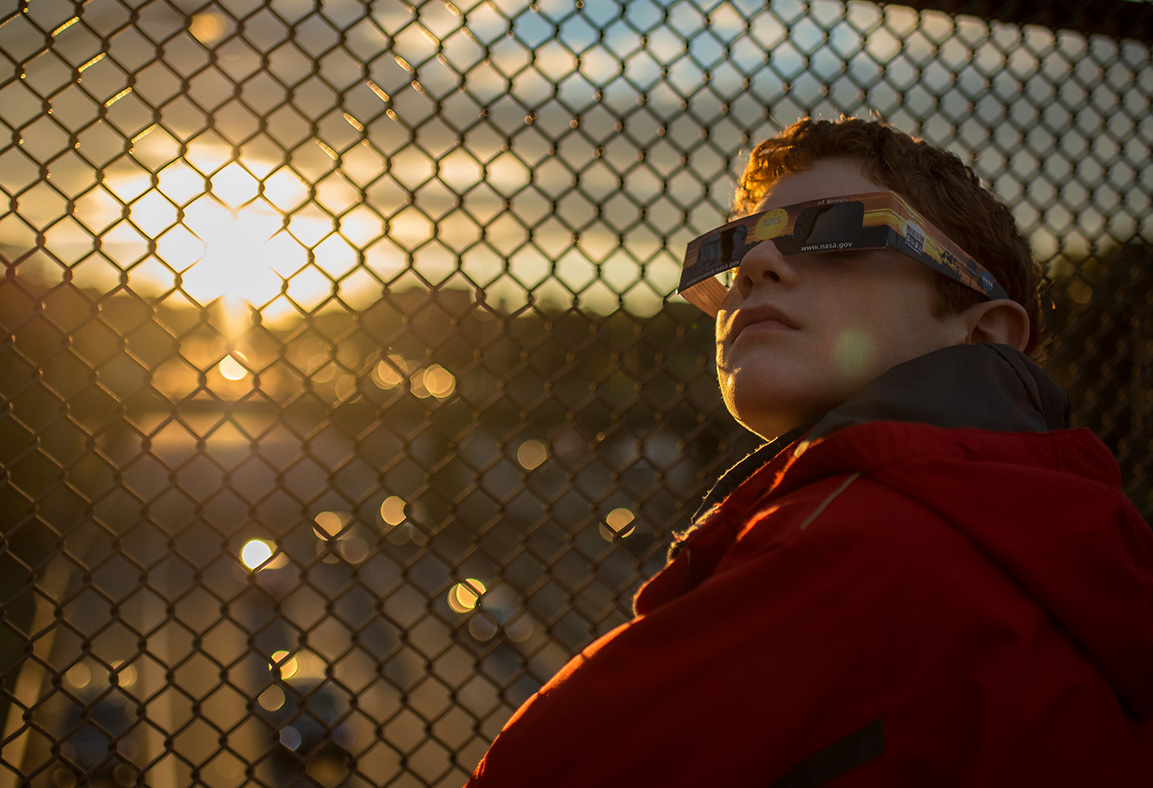 Un niño usa gafas protectoras para mirar un eclipse parcial de sol en Arlington, Virginia. NASA/Bill Ingalls