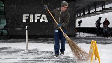 Un barrendero remueve la nieve afuera de la FIFA