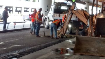 Los obreros están excavando en la carretera enfrente de la zona de llegadas de la Terminal 5 para reparar la cañería.