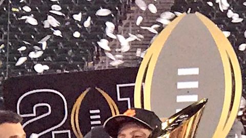Entrenador y jugadores estrella de los Tigers de Clemson celebran con el trofeo de campeones del futbol americano colegial.