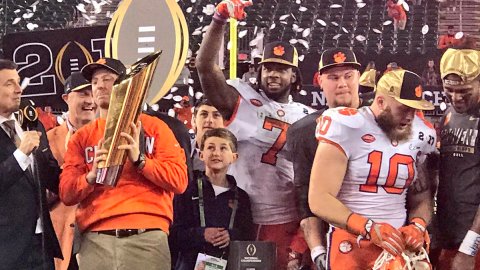 Entrenador y jugadores estrella de los Tigers de Clemson celebran con el trofeo de campeones del futbol americano colegial.