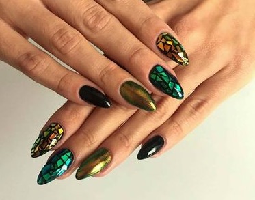 Las uñas con figuras geométricas, creadas con 'foile' sobre acrílico negro, da una apariencia futurista. 
