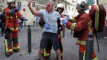 Un hincha inglés es ayudado tras ser agredido por Hooligans rusos durante la Eurocopa.