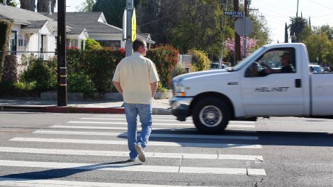 Un policía de civil cruza la esquina de la Avenida Woodley y la Calle Basset en Van Nuys durante el operativo de tránsito. (Aurelia Ventura/La Opinion)