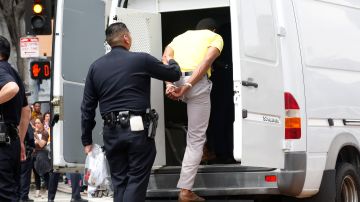 Activista siendo detenido por un agente.
